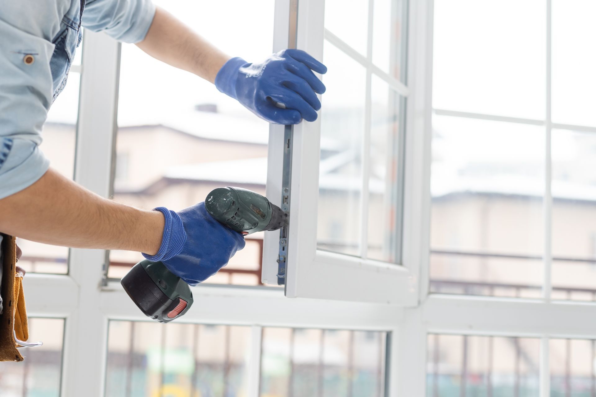 Two men are installing a window in a room.