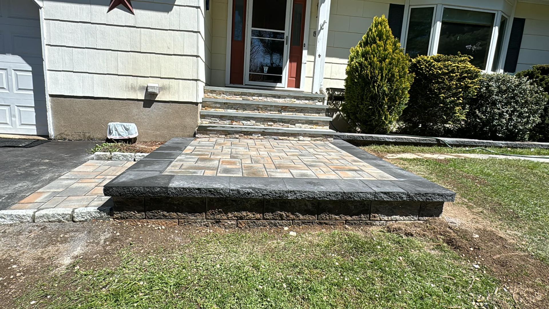 A brick walkway is being built in front of a house.