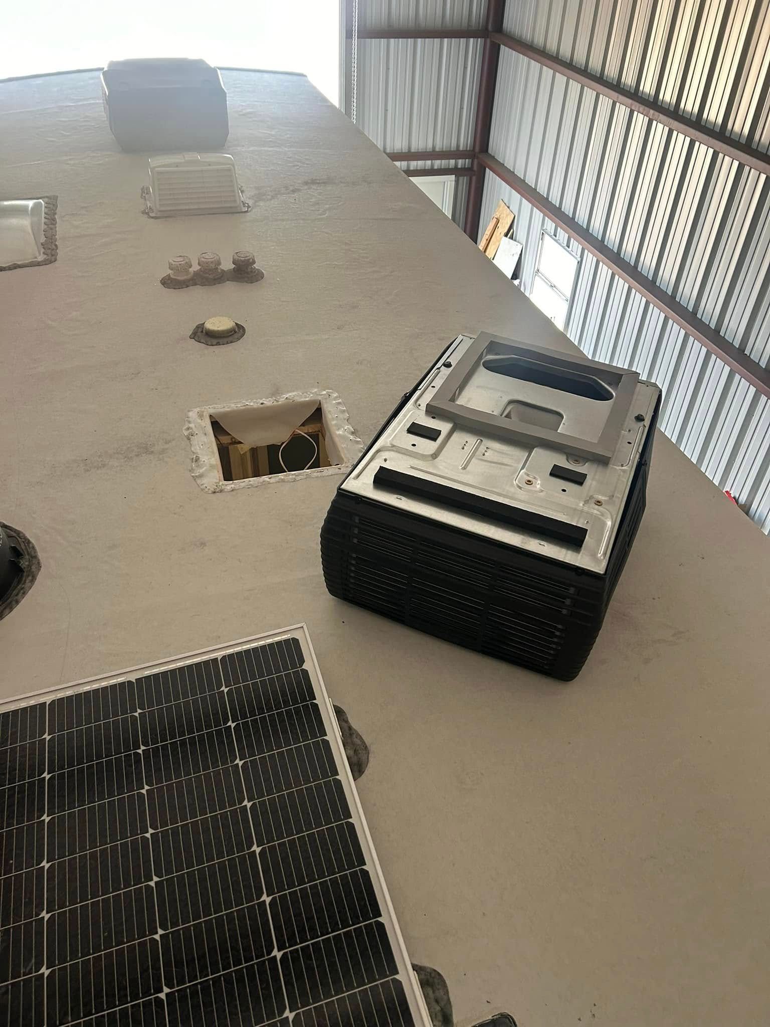 A projector is sitting on top of a table next to a solar panel.