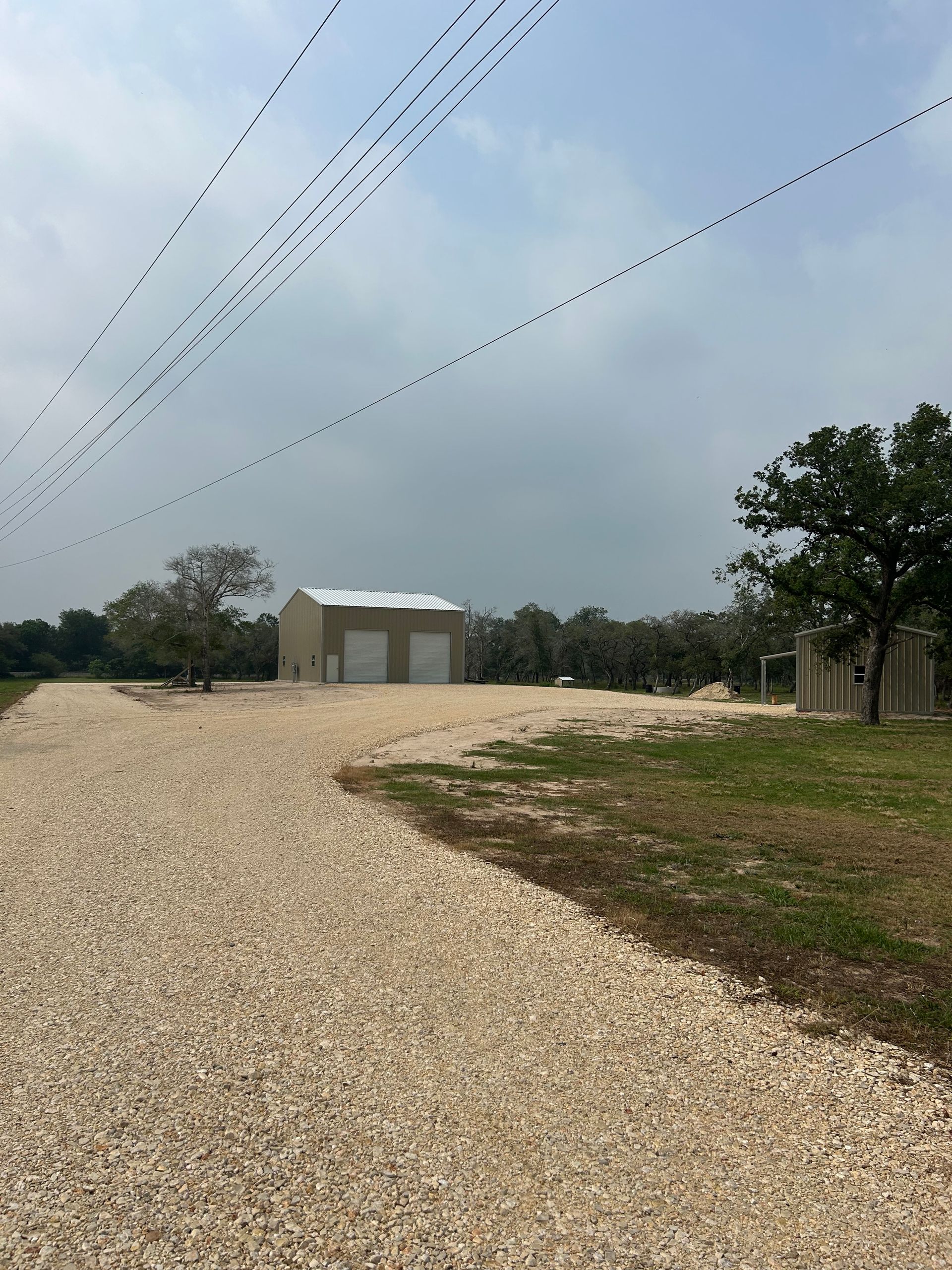 A gravel road with a building in the background