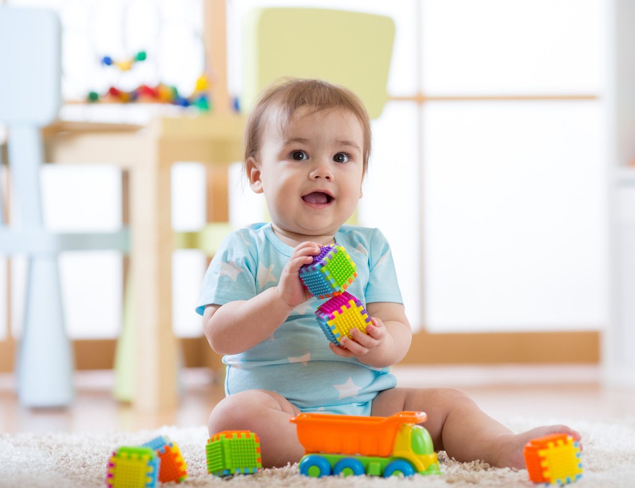 baby boy playing toys in nursery or daycare