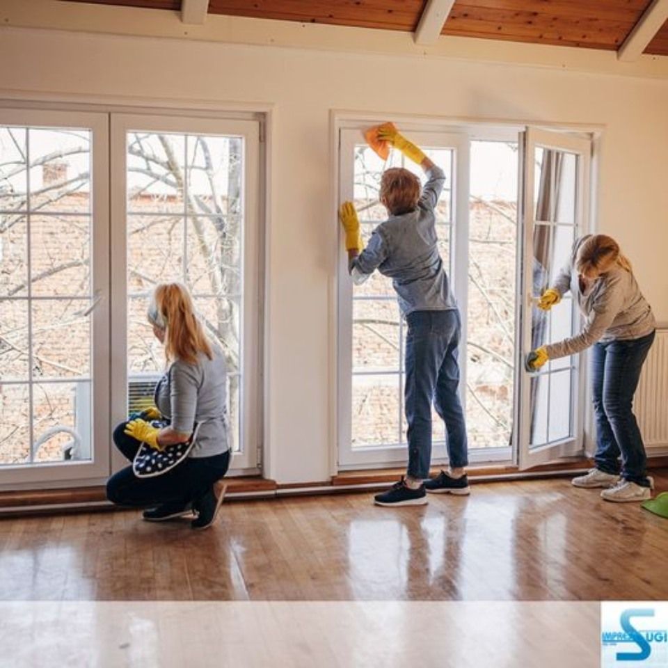 Un gruppo di persone sta pulendo una finestra in una stanza.