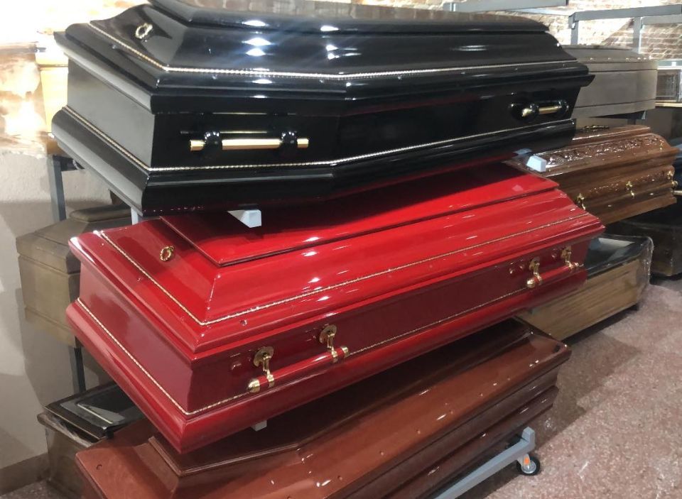 Pila di bare lucidate di vari colori, tra cui nero e rosso, all'interno.