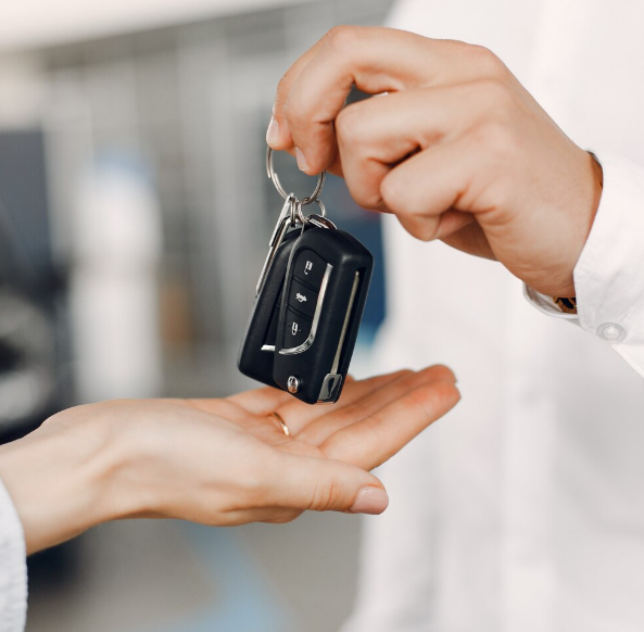 Persona entregando las llaves del coche a otra persona.