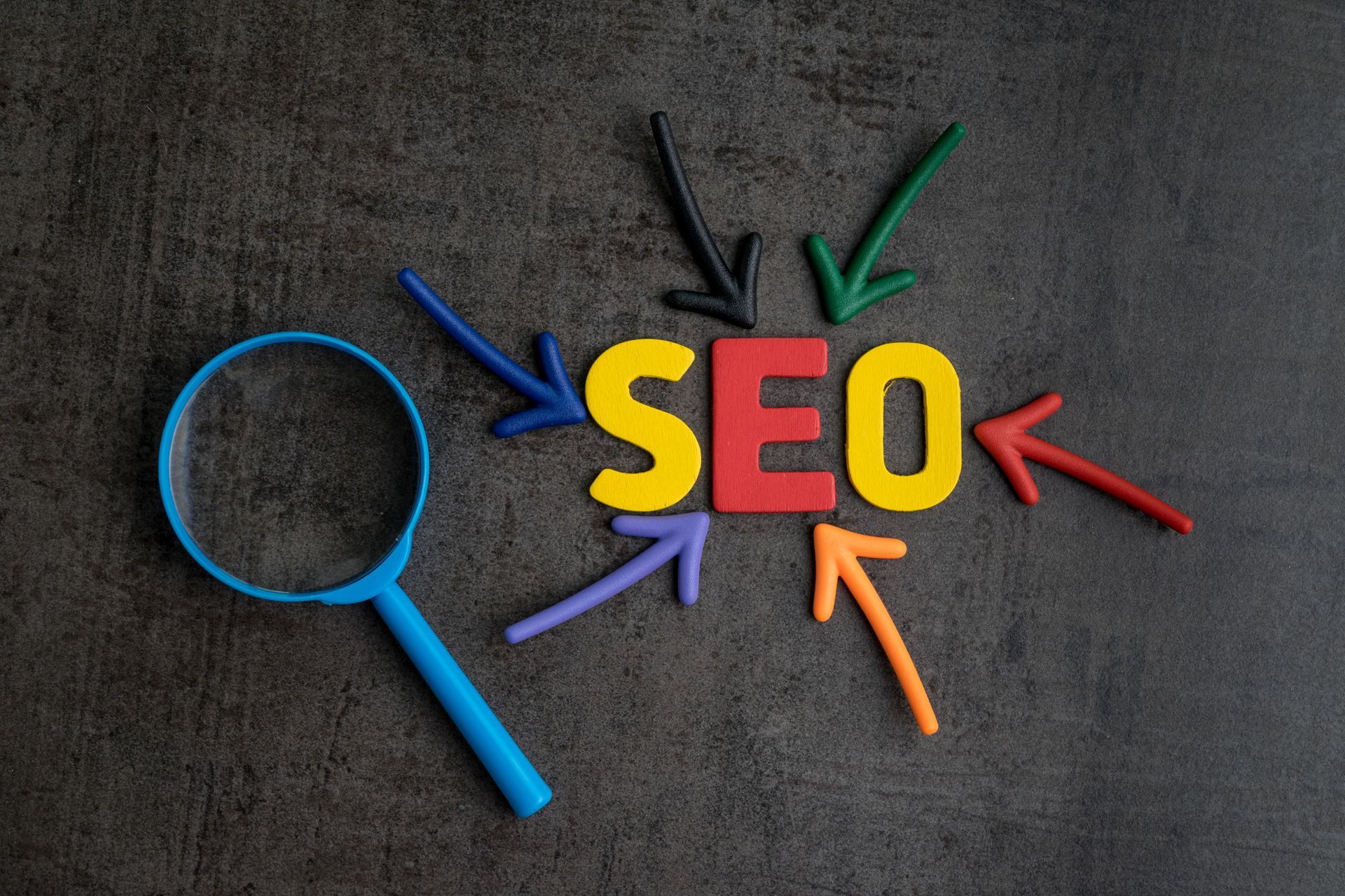The word SEO is surrounded by colorful arrows and a magnifying glass. Mahogany Tech 