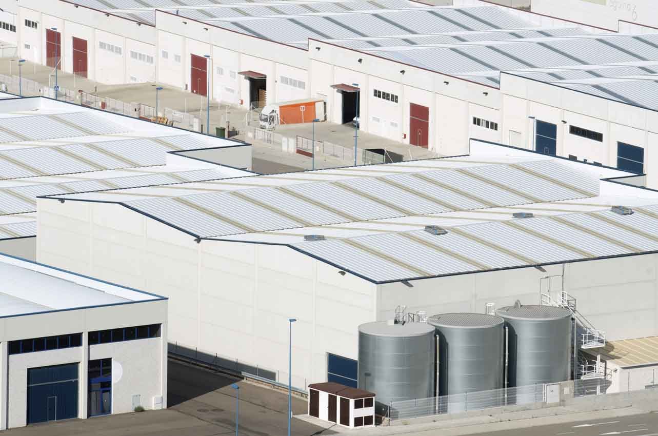 An aerial view of a warehouse with a lot of roofs