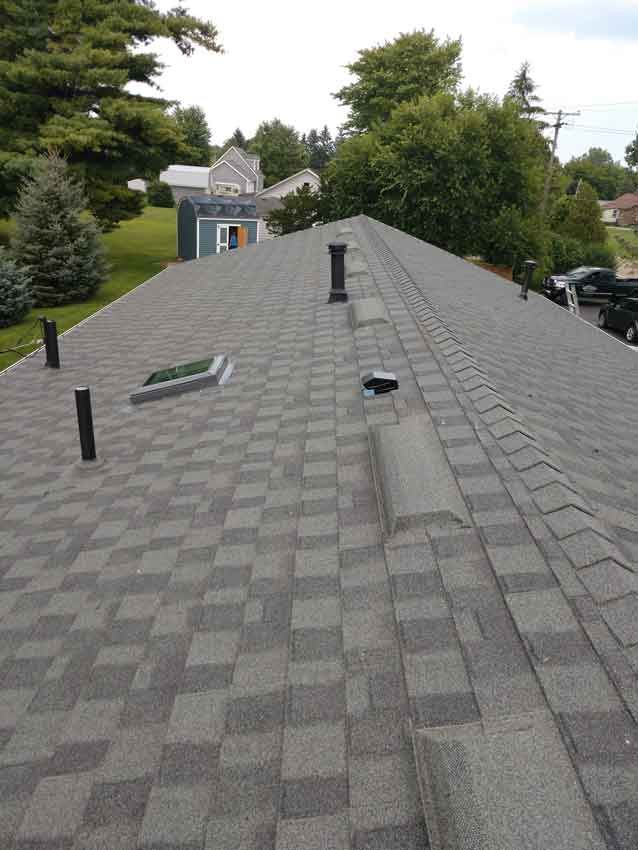 A roof with a skylight and a chimney on it