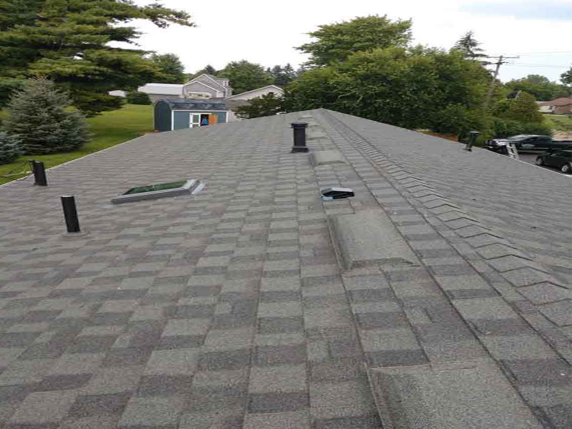 A roof with a lot of shingles and a chimney on it.