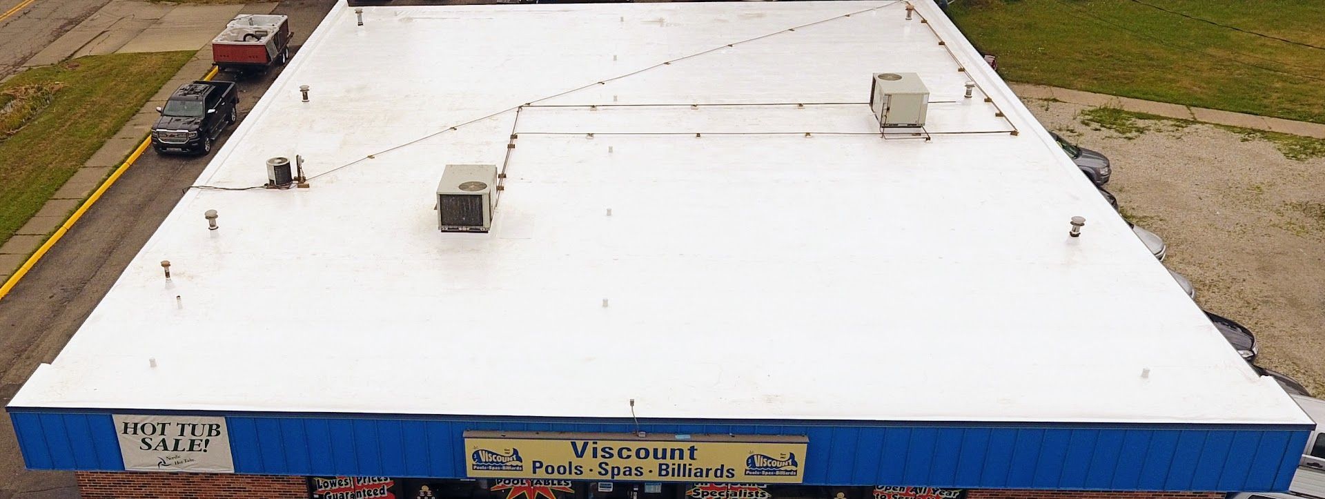 An aerial view of a building with a white roof