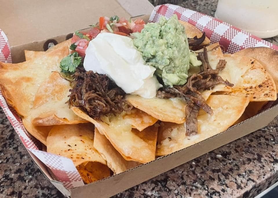 A Box of Nachos With Guacamole and Sour Cream on a Table — Cafe Nosh in Taree, NSW
