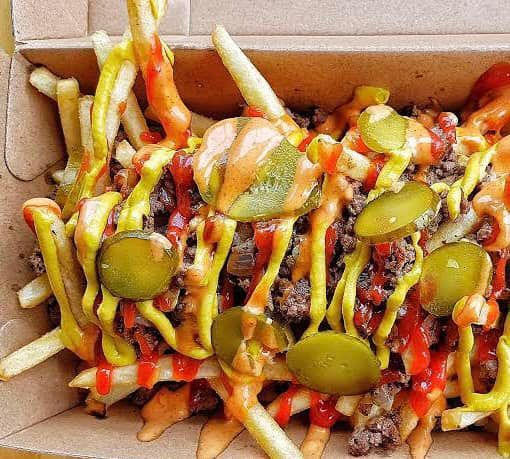 A Close Up of a Box of French Fries With Sauces and Pickles — Cafe Nosh in Taree, NSW