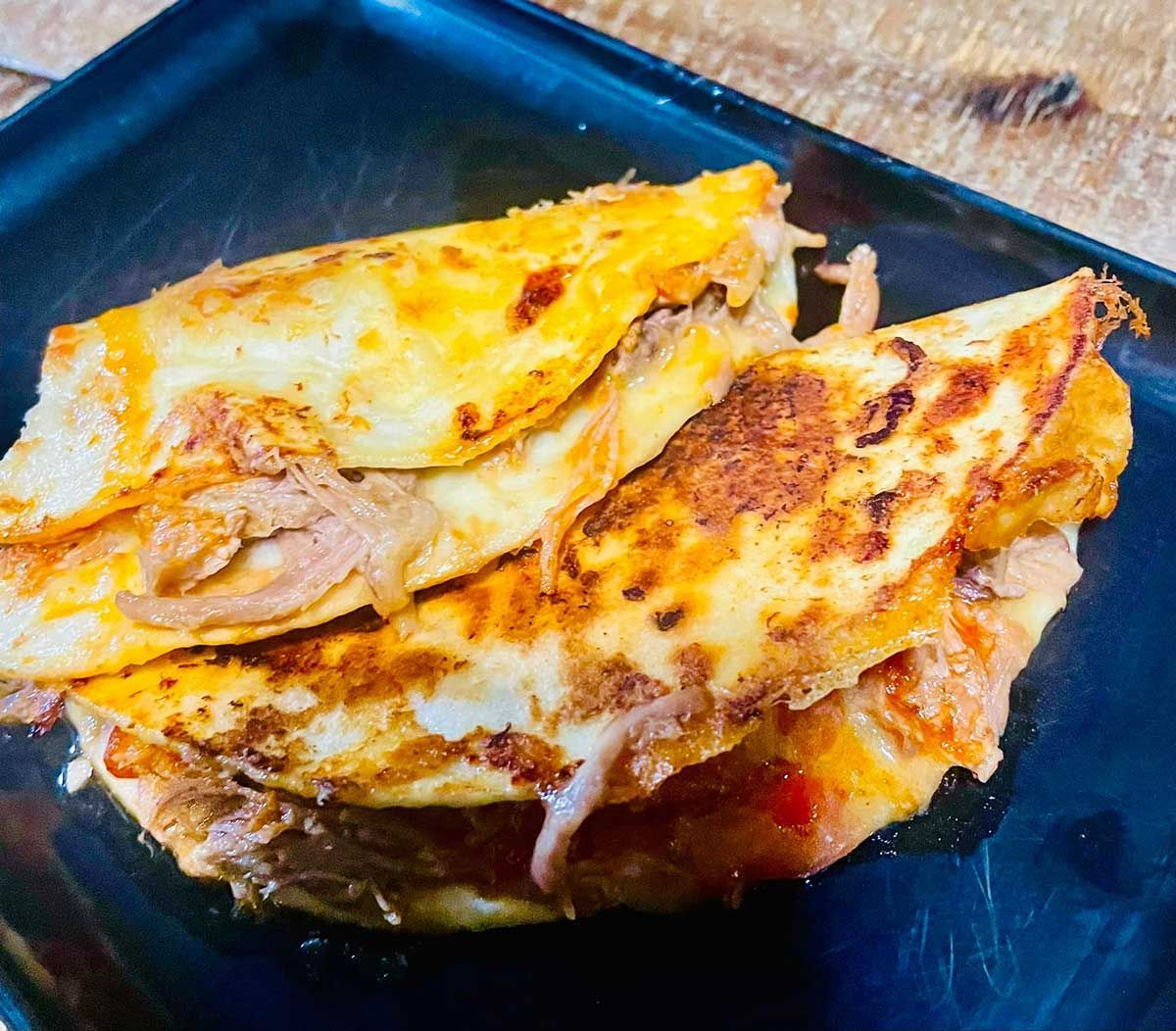 A Close Up of a Quesadilla on a Black Plate — Cafe Nosh in Taree, NSW