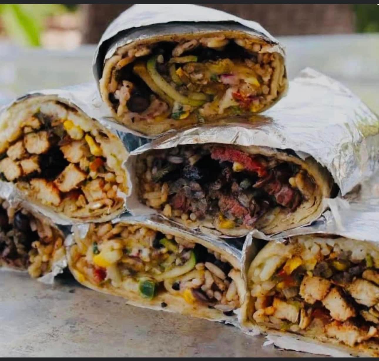 A Bunch of Burritos Are Stacked on Top of Each Other — Cafe Nosh in Taree, NSW