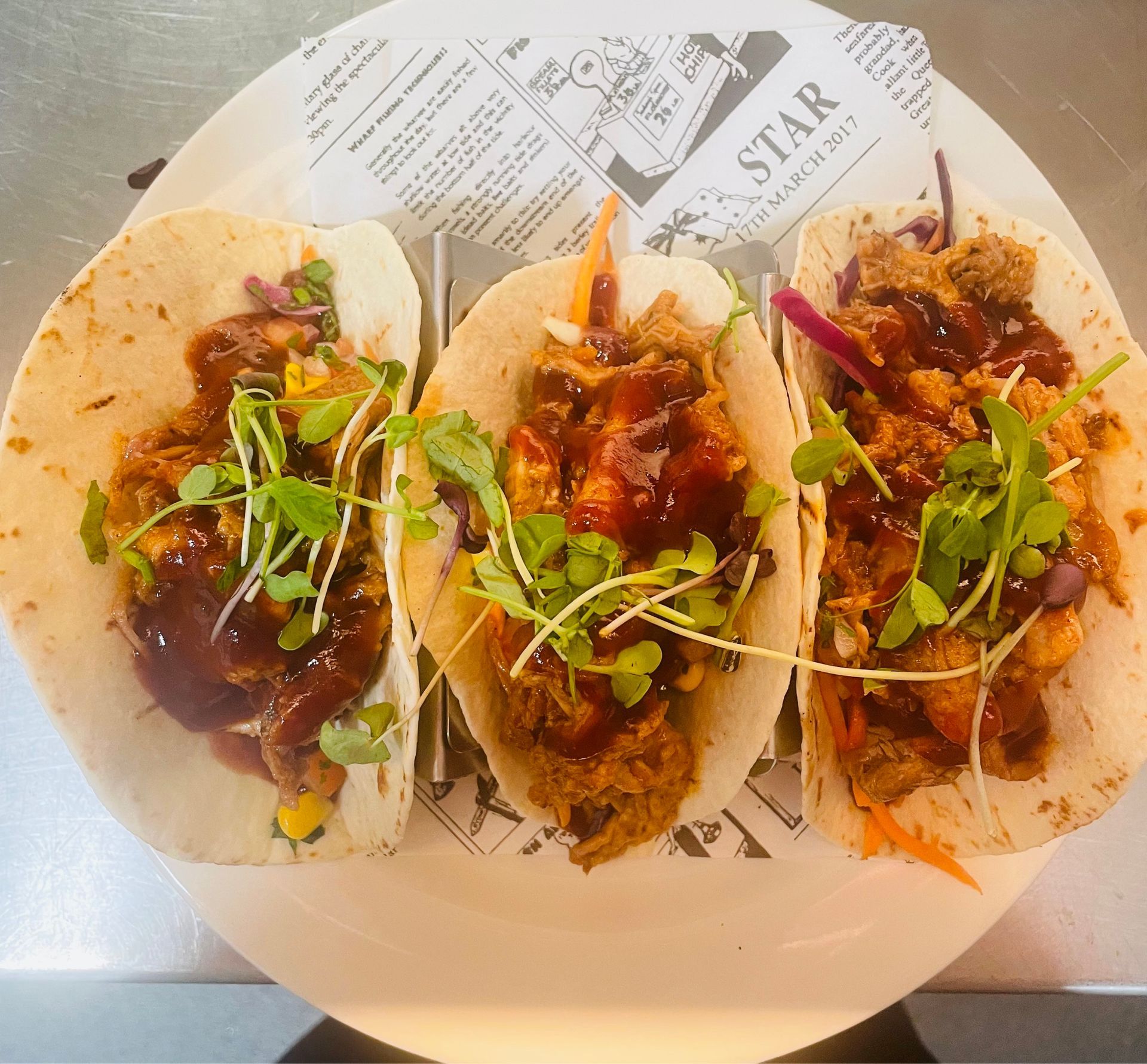 A Plate of Food With Eggs, Bacon, Sausages and Tomatoes on a Table — Cafe Nosh in Taree, NSW