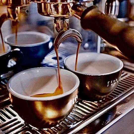 A Coffee Machine Pouring Coffee Into Two Mugs — Cafe Nosh in Taree, NSW