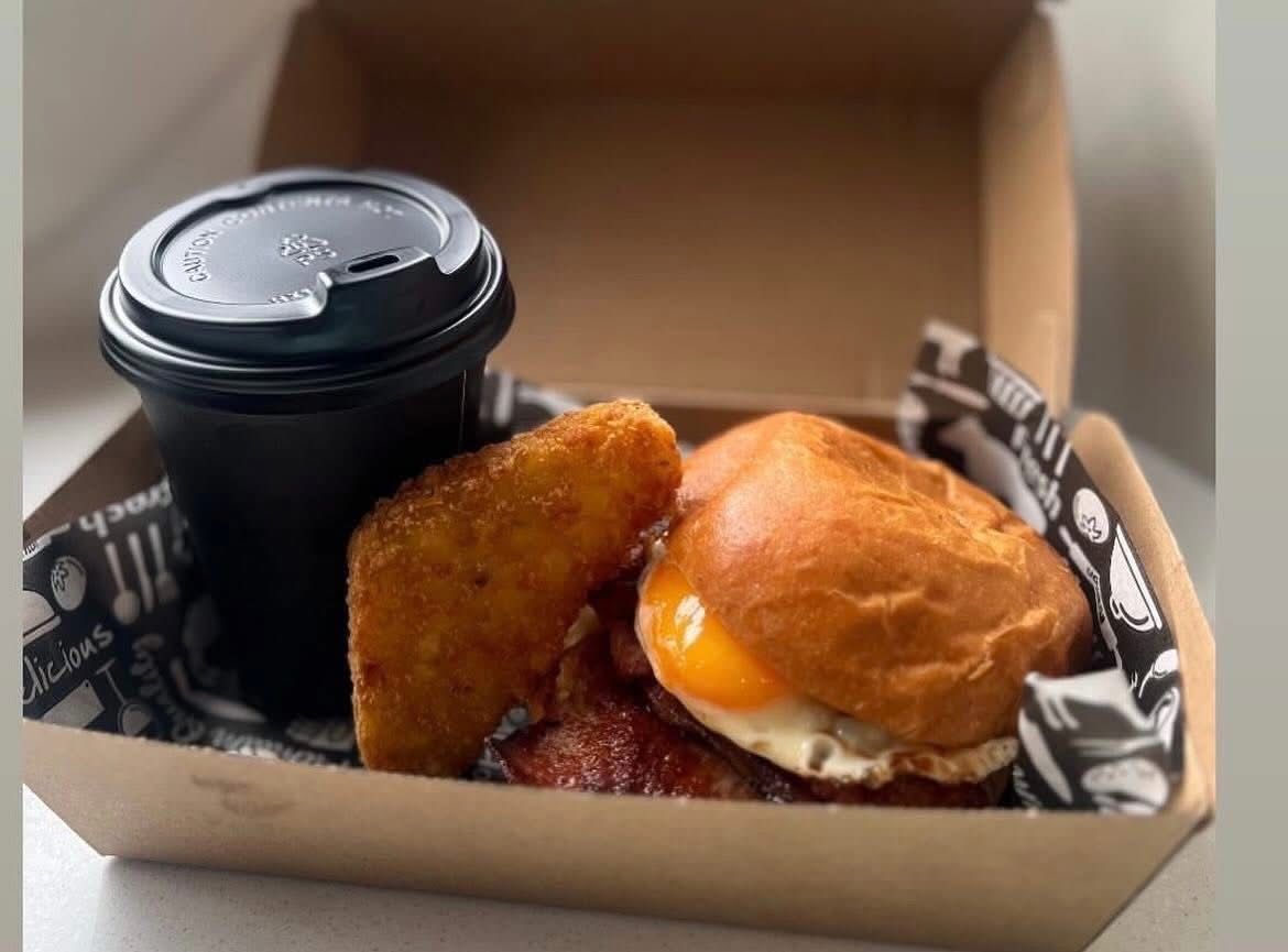 Breakfast box: Coffee, hash brown, and egg sandwich in a cardboard container. — Cafe Nosh in Taree, NSW