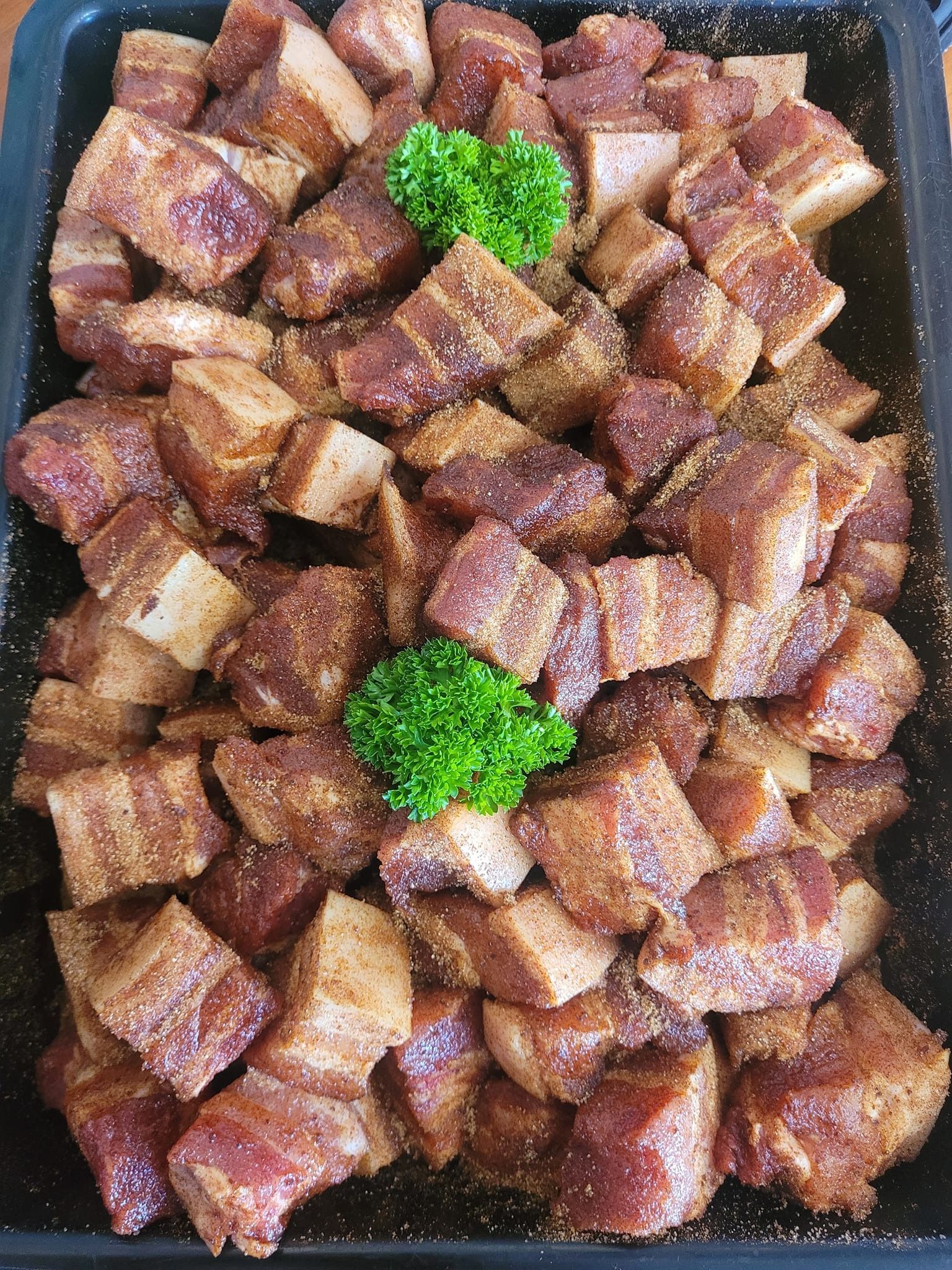 Cubes of Seasoned Pork Belly in a Black Tray — Drovers Meats in Coffs Harbour, NSW