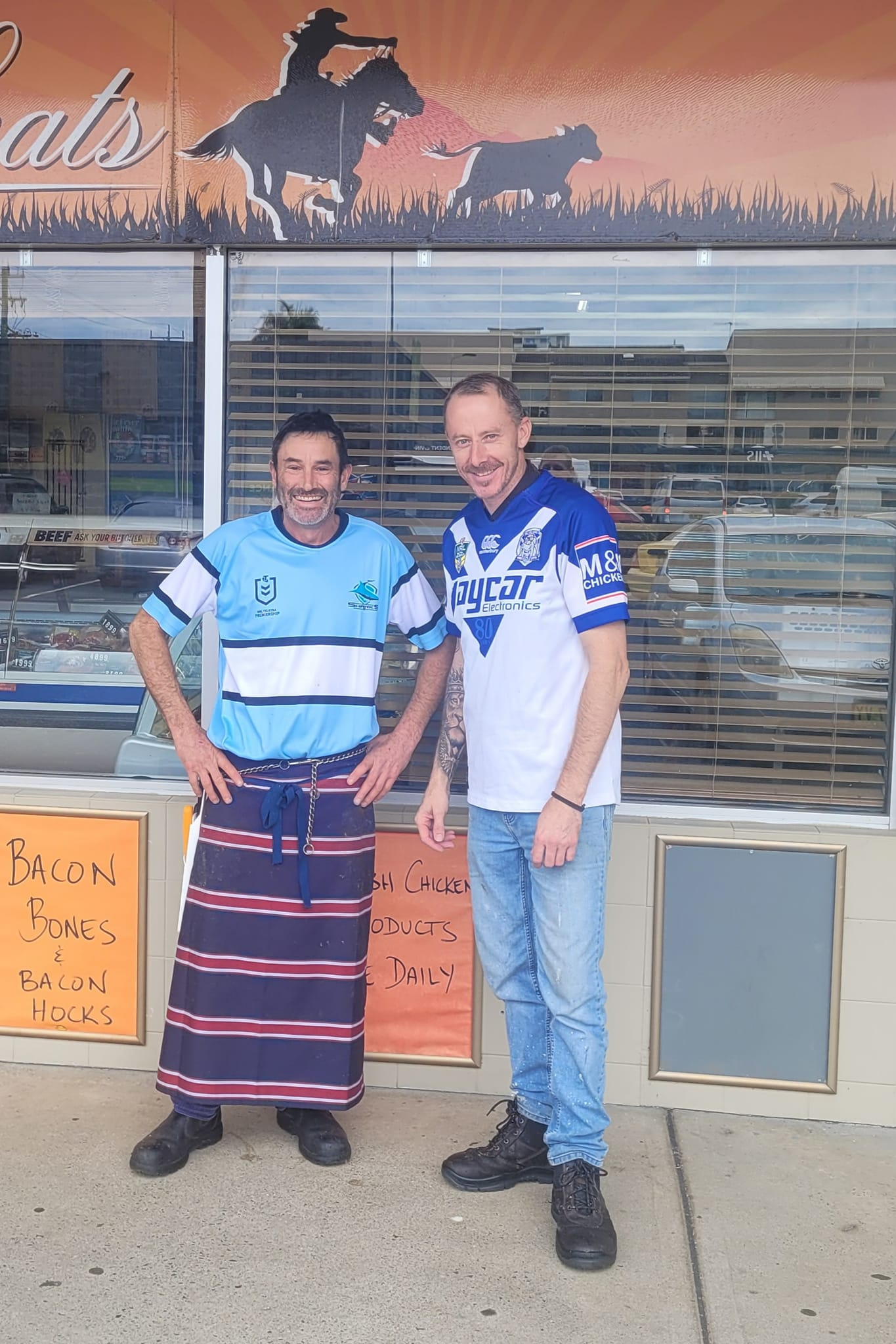 Two Men Pose in Front of a Store with a Cowboy Sign — Drovers Meats in Coffs Harbour, NSW