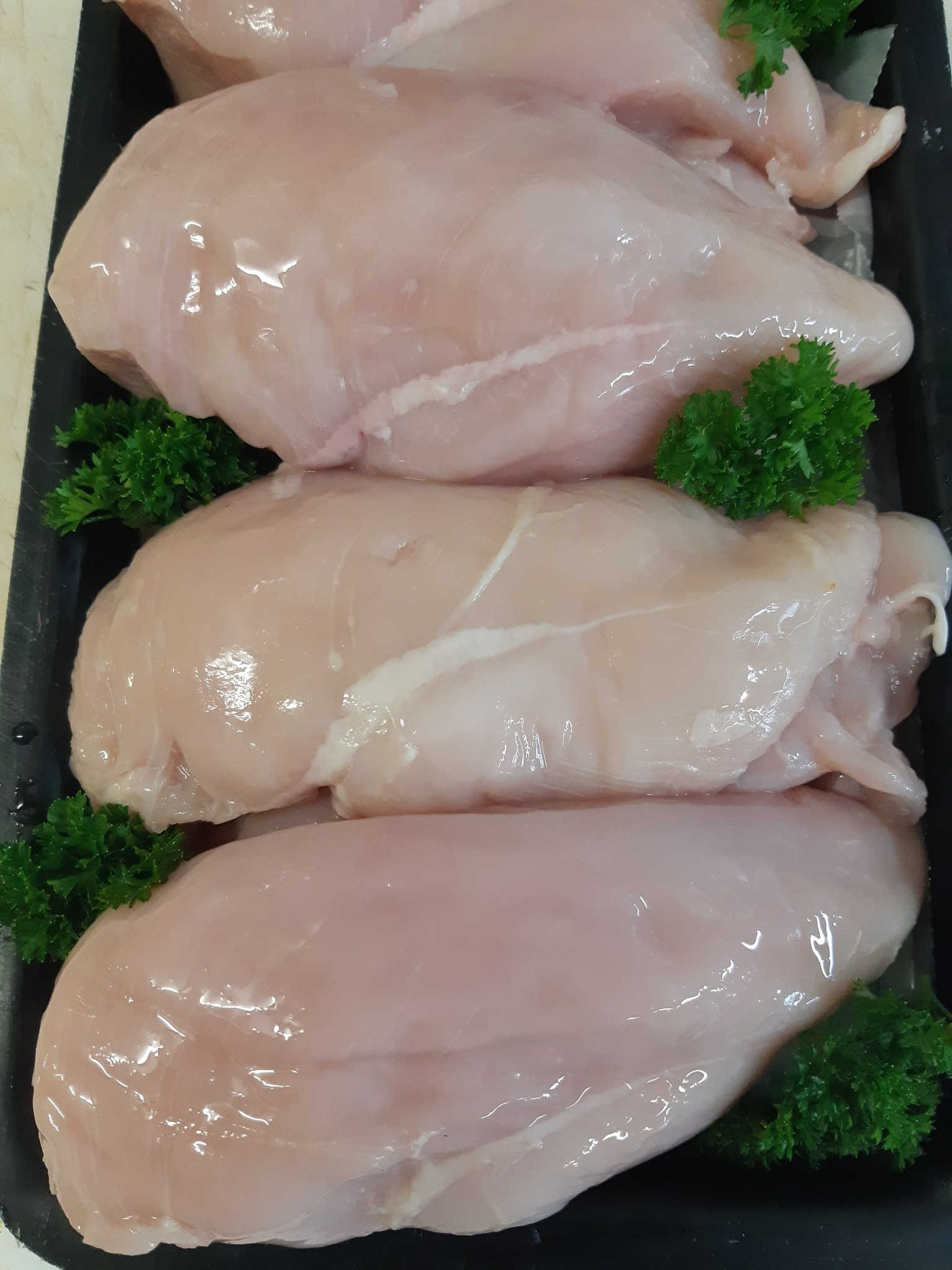 Raw Chicken Breasts Arranged on a Black Tray — Drovers Meats in Coffs Harbour, NSW