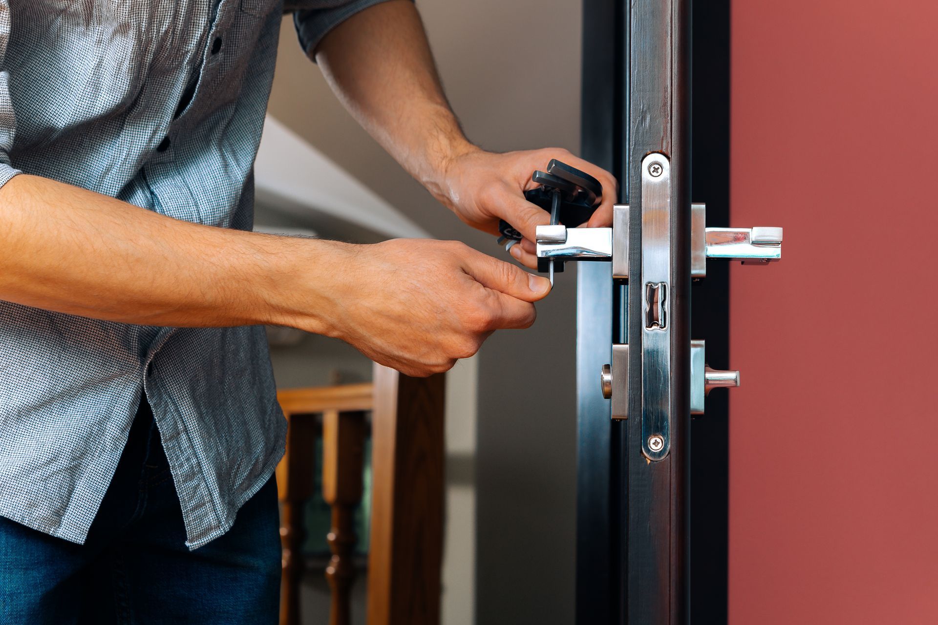 Person unlocking a black door with a key