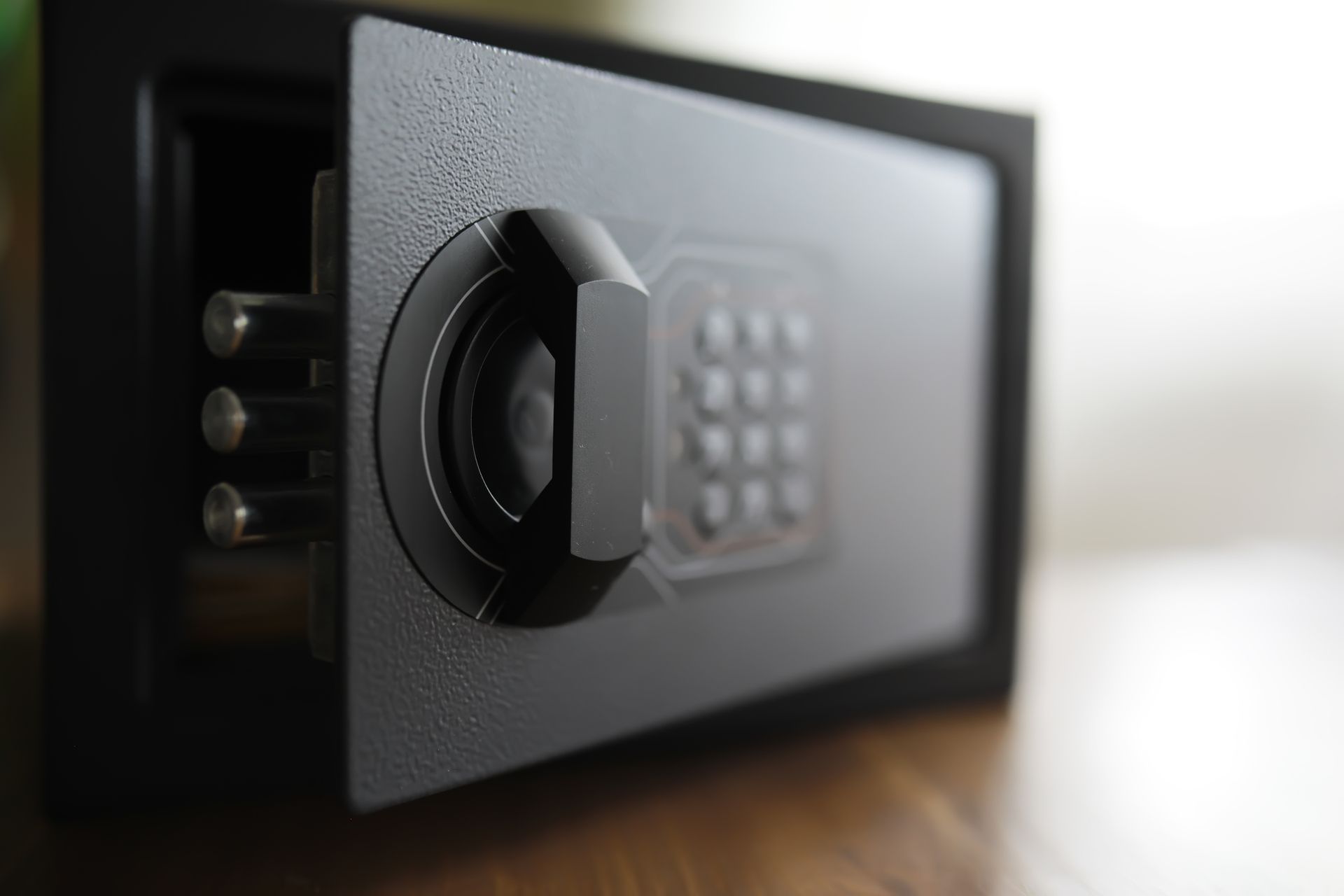 Open black safe with keypad on a wooden surface