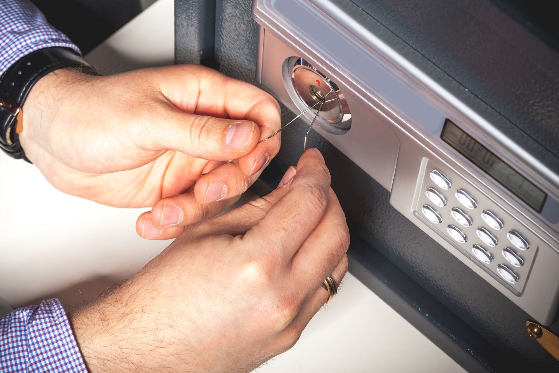 Hands picking a lock on a safe