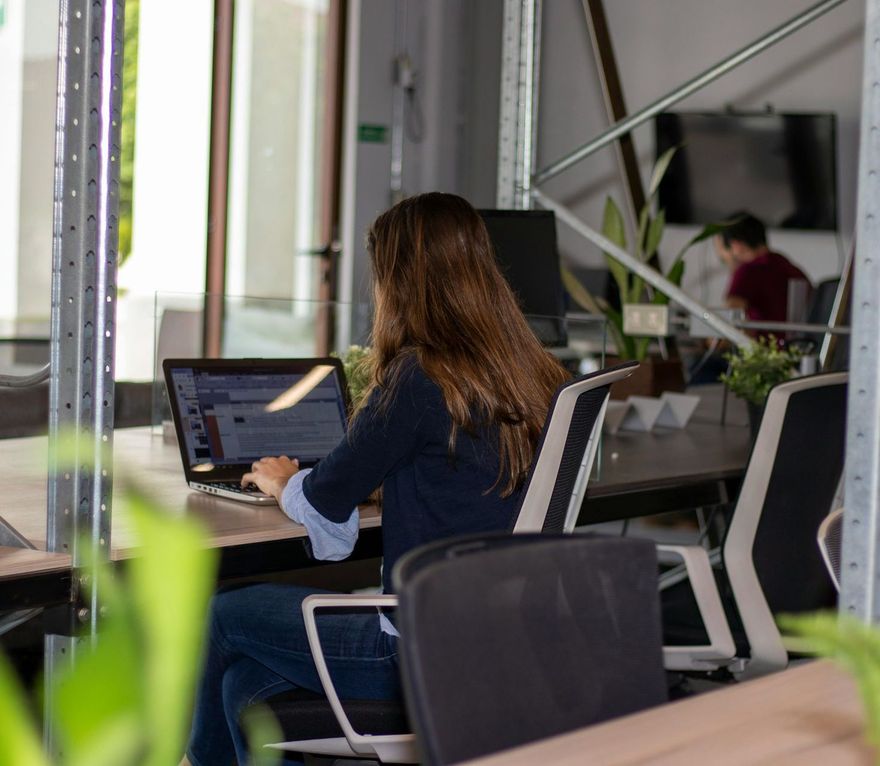 A woman is sitting at a desk using a laptop computer