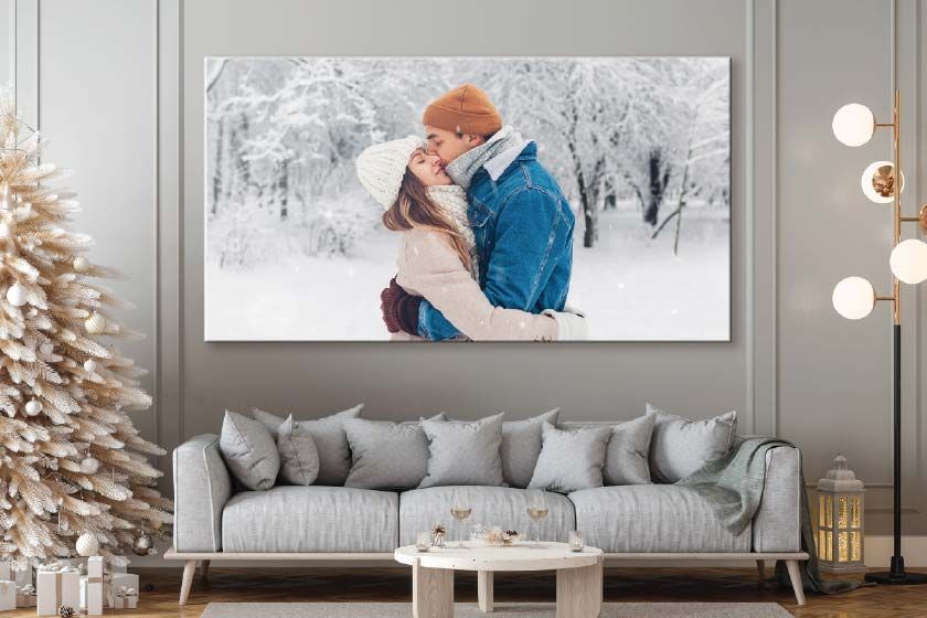 Canvas print on a wall with two people walking on the beach at sunset