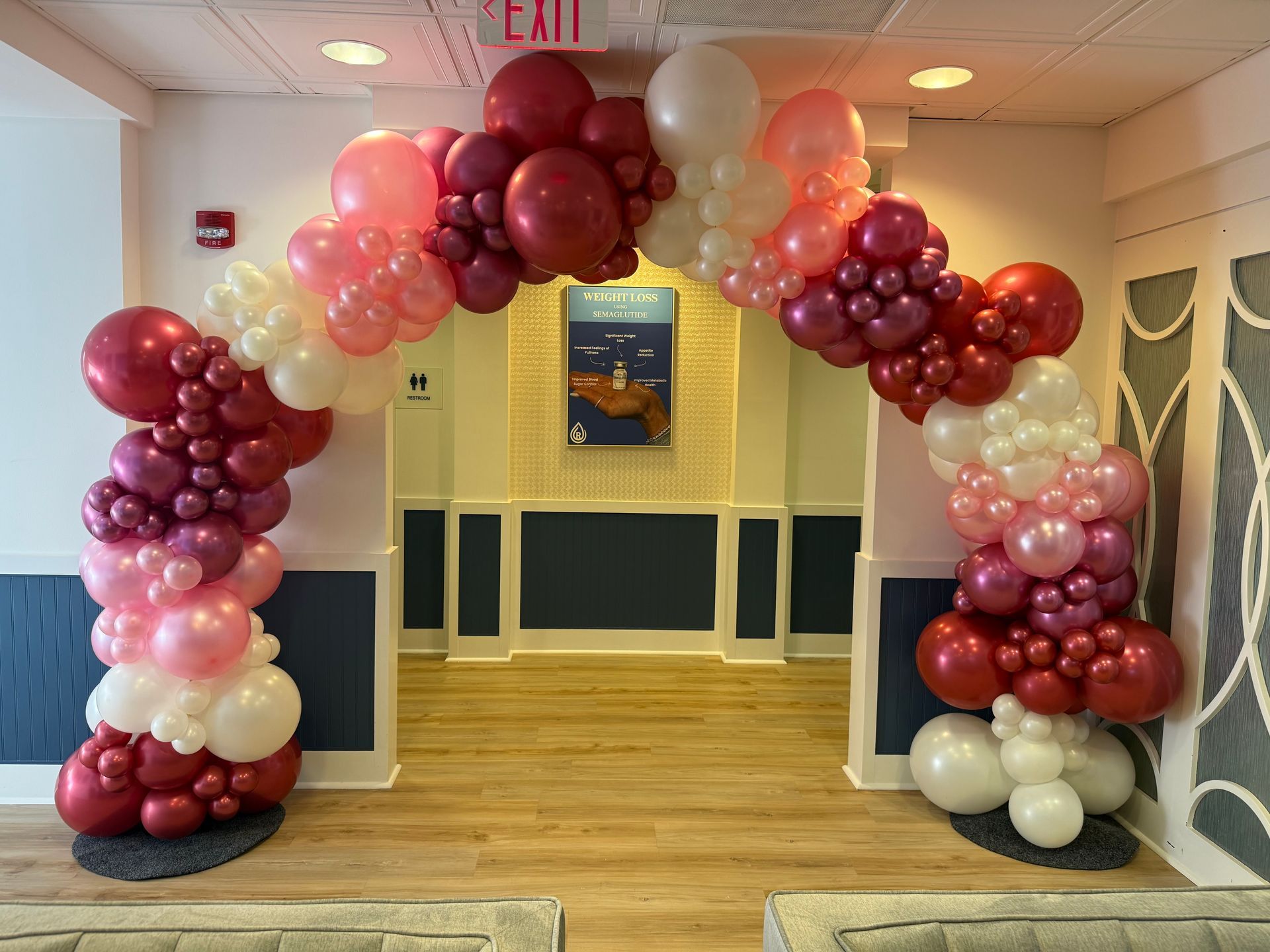 A large arch made of red , green and white balloons