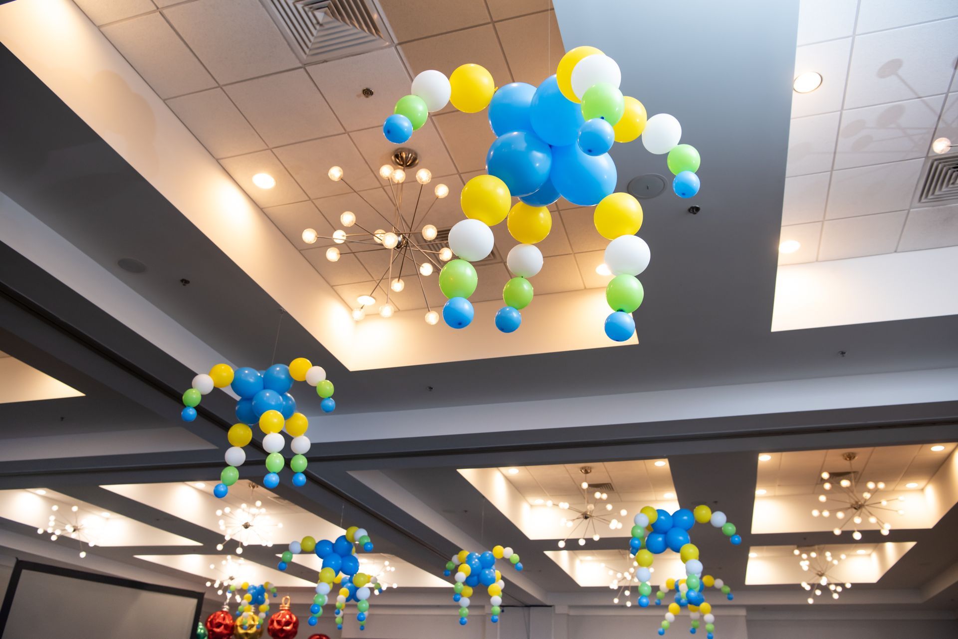Balloons are hanging from the ceiling of a room