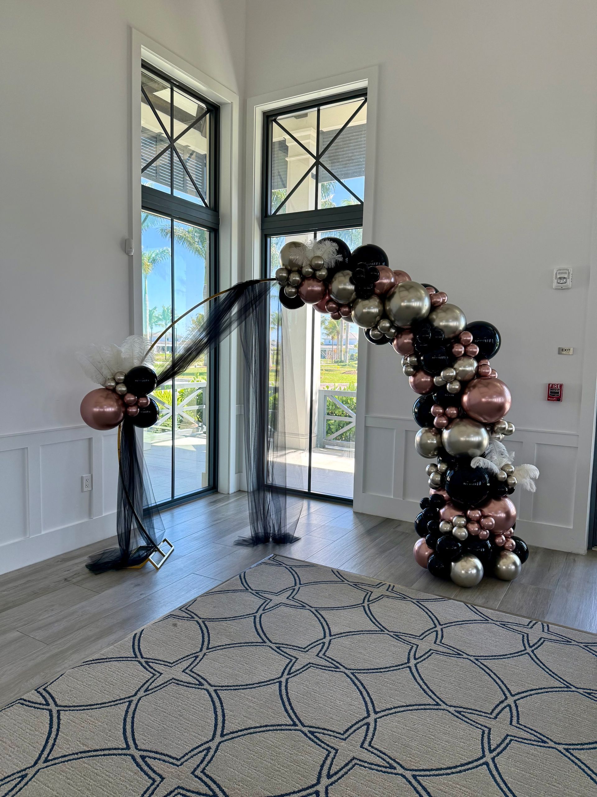 A red , white and blue balloon arch in a room