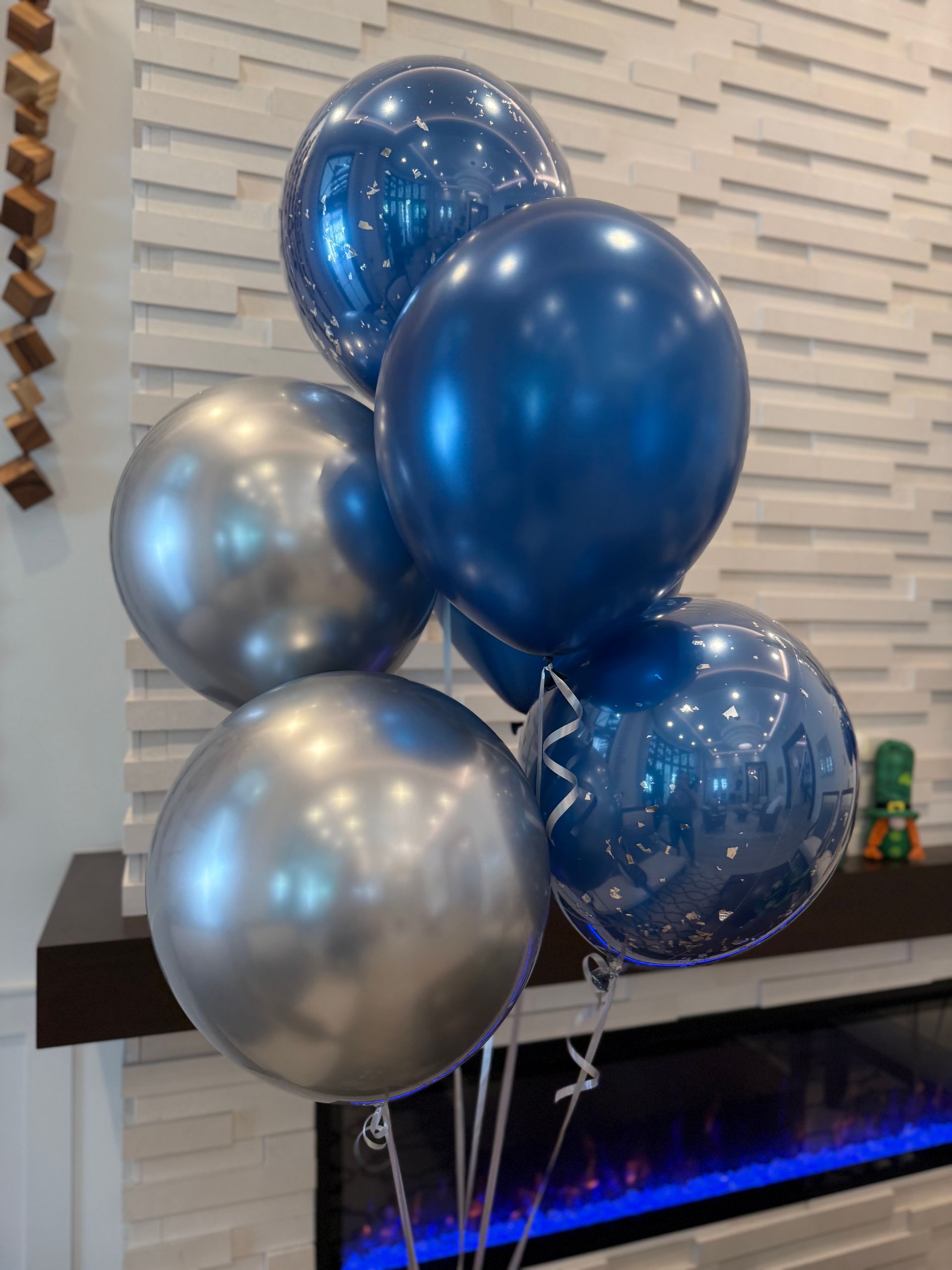 A bunch of silver balloons with black bows on them