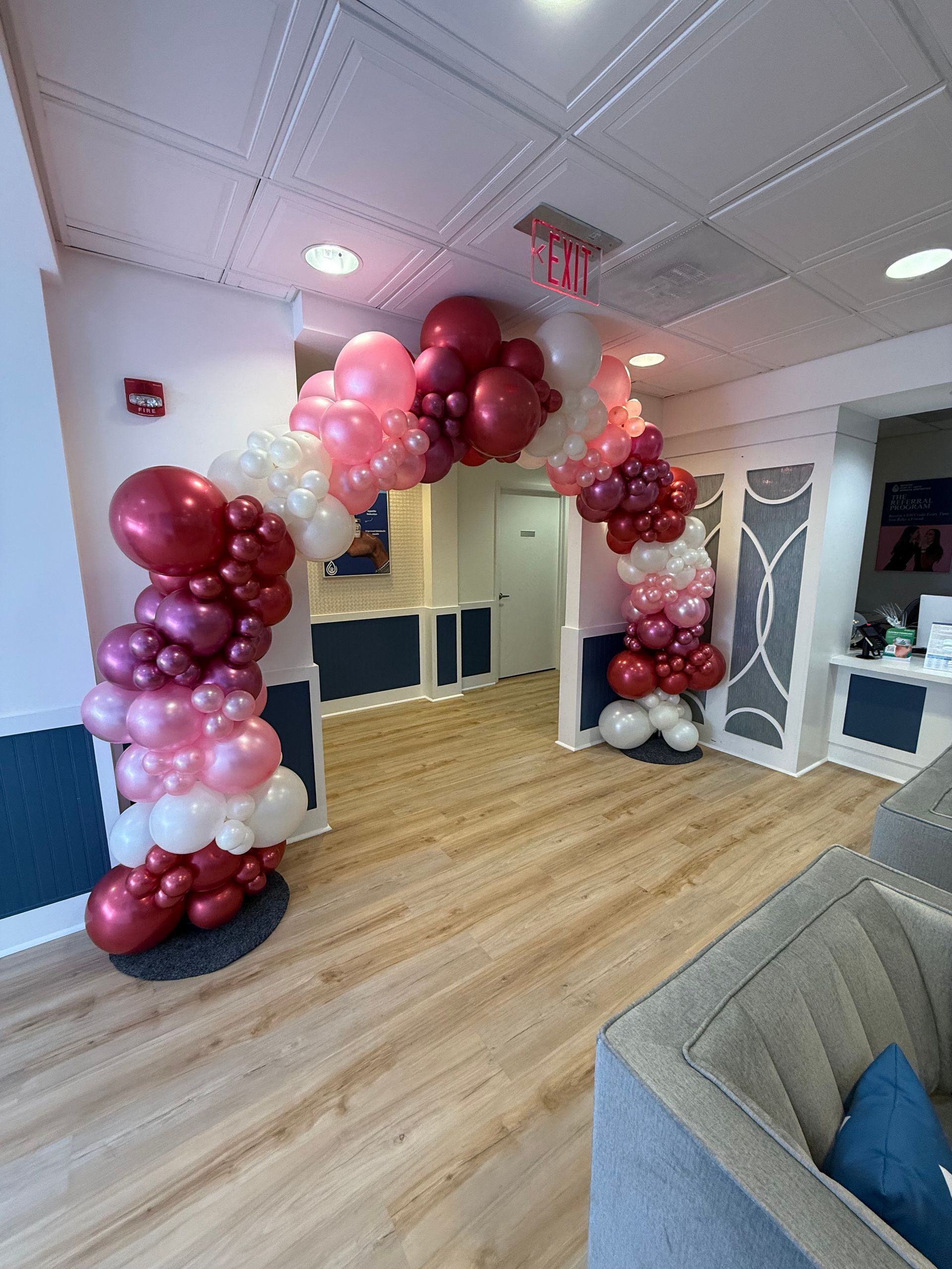 A red white and blue balloon arch in a room
