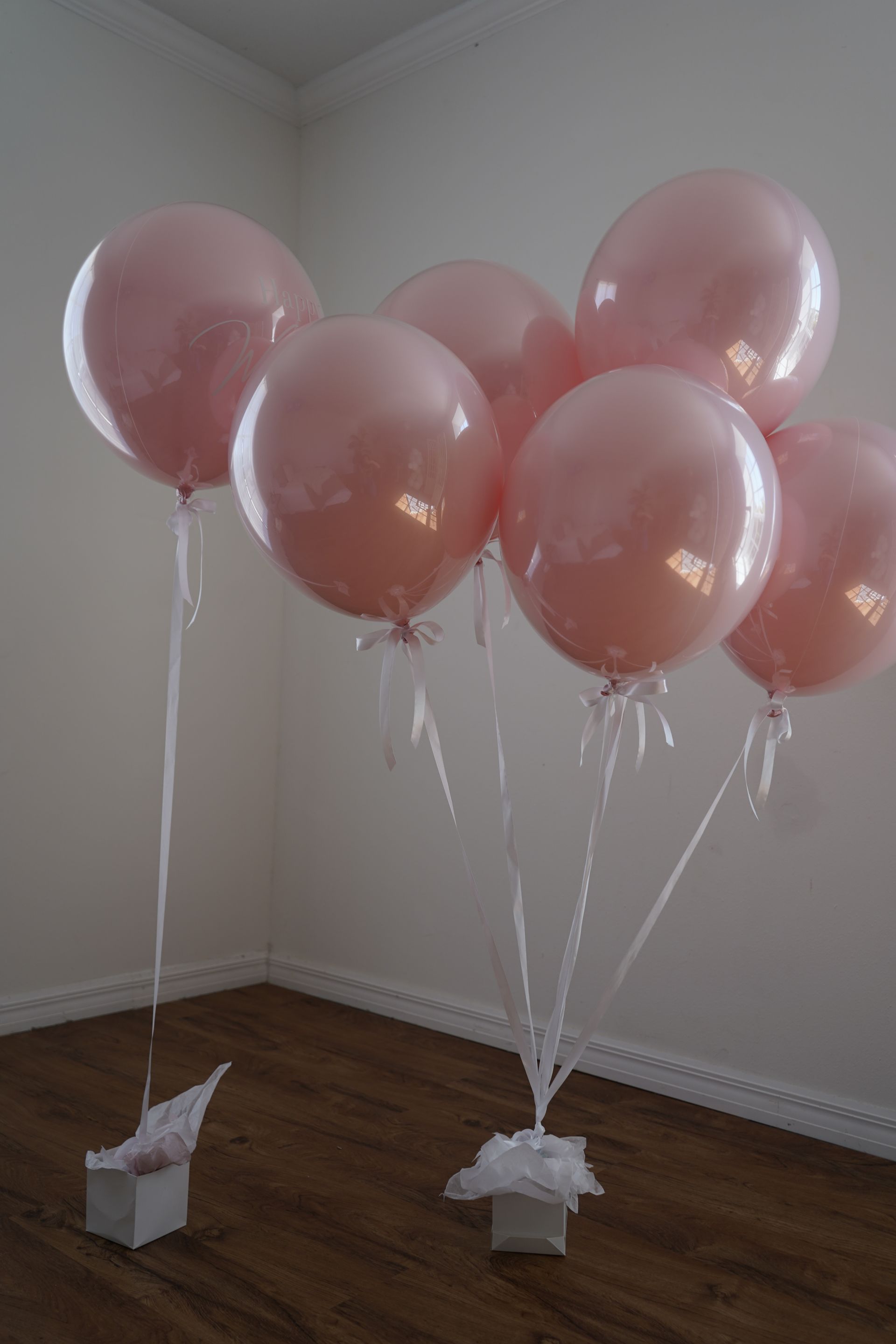 A bunch of pink balloons hanging from the ceiling