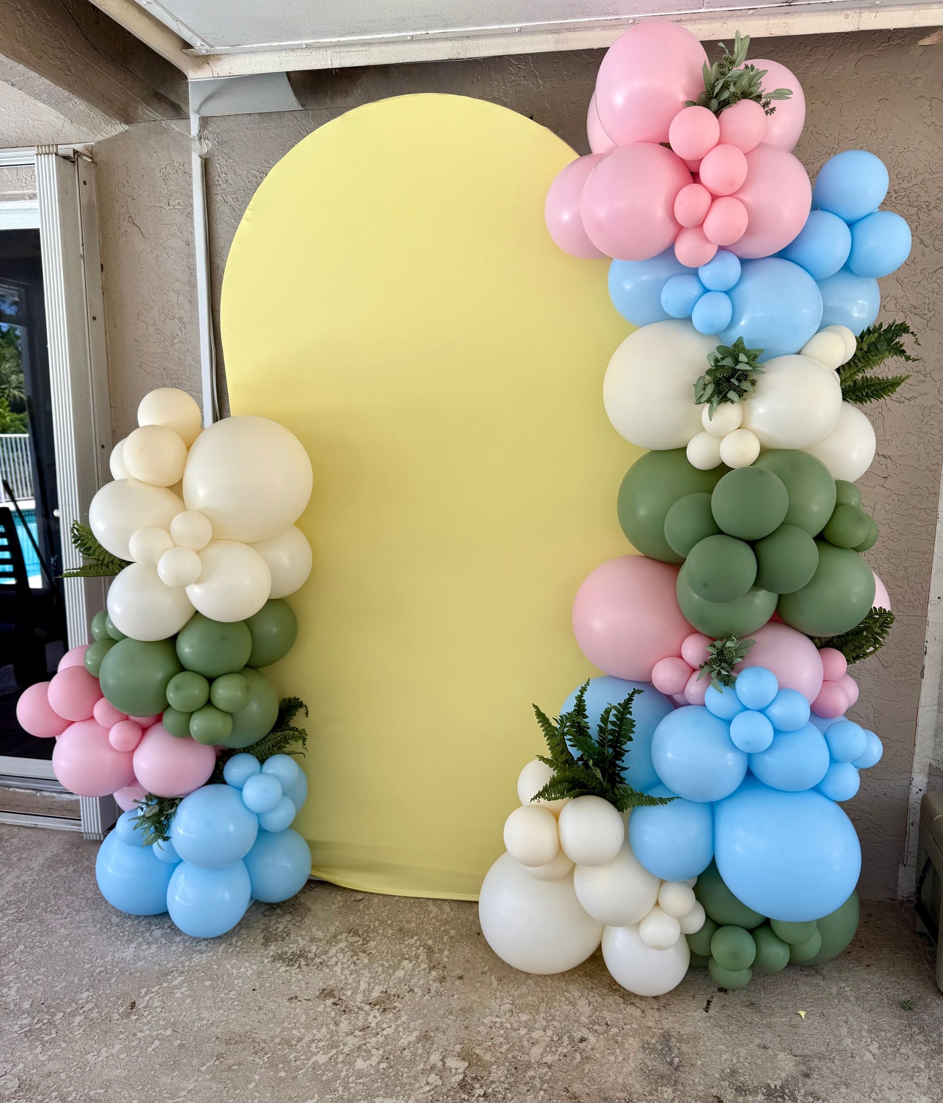A witch is standing next to a bunch of balloons.