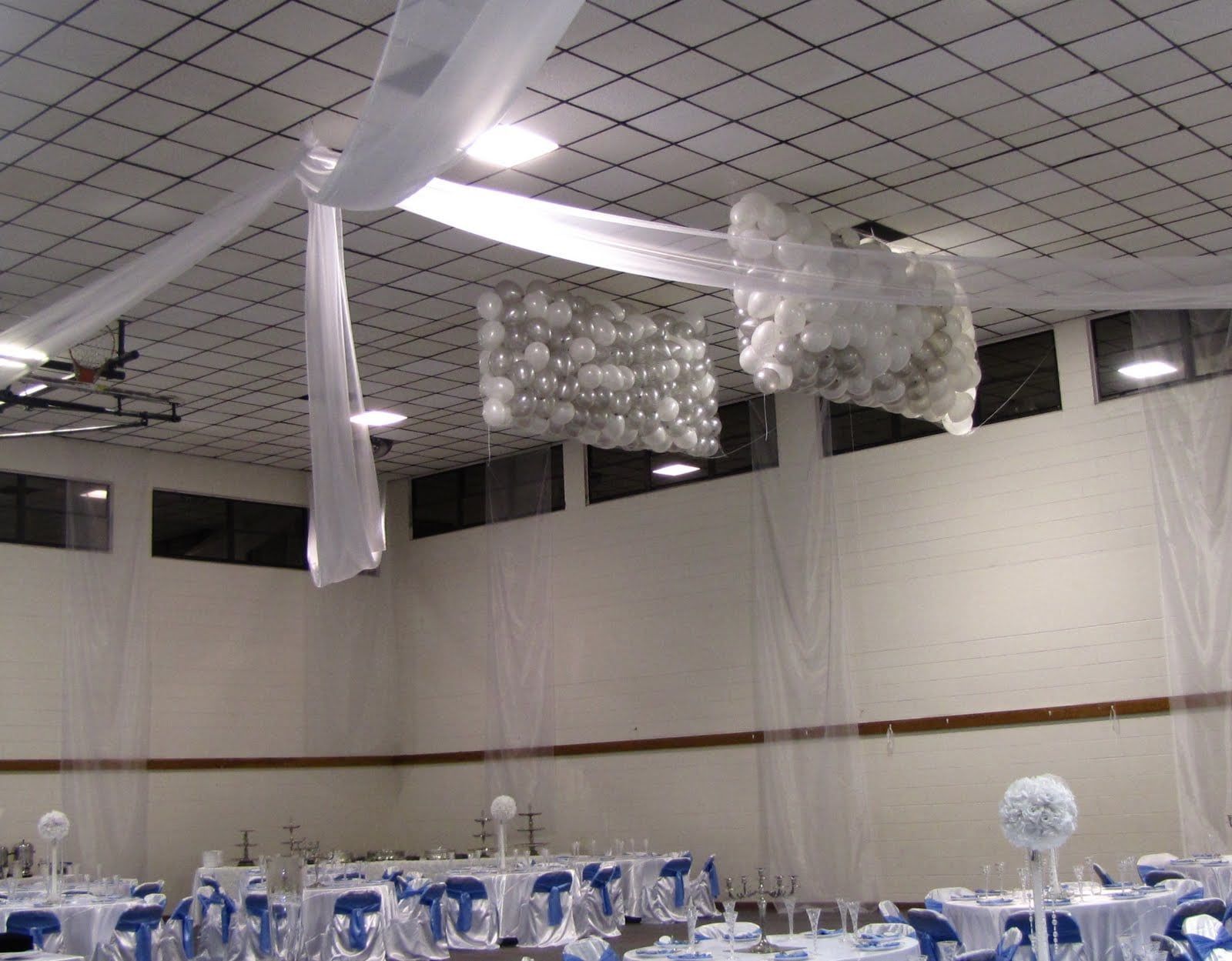 A room with tables and chairs and balloons hanging from the ceiling