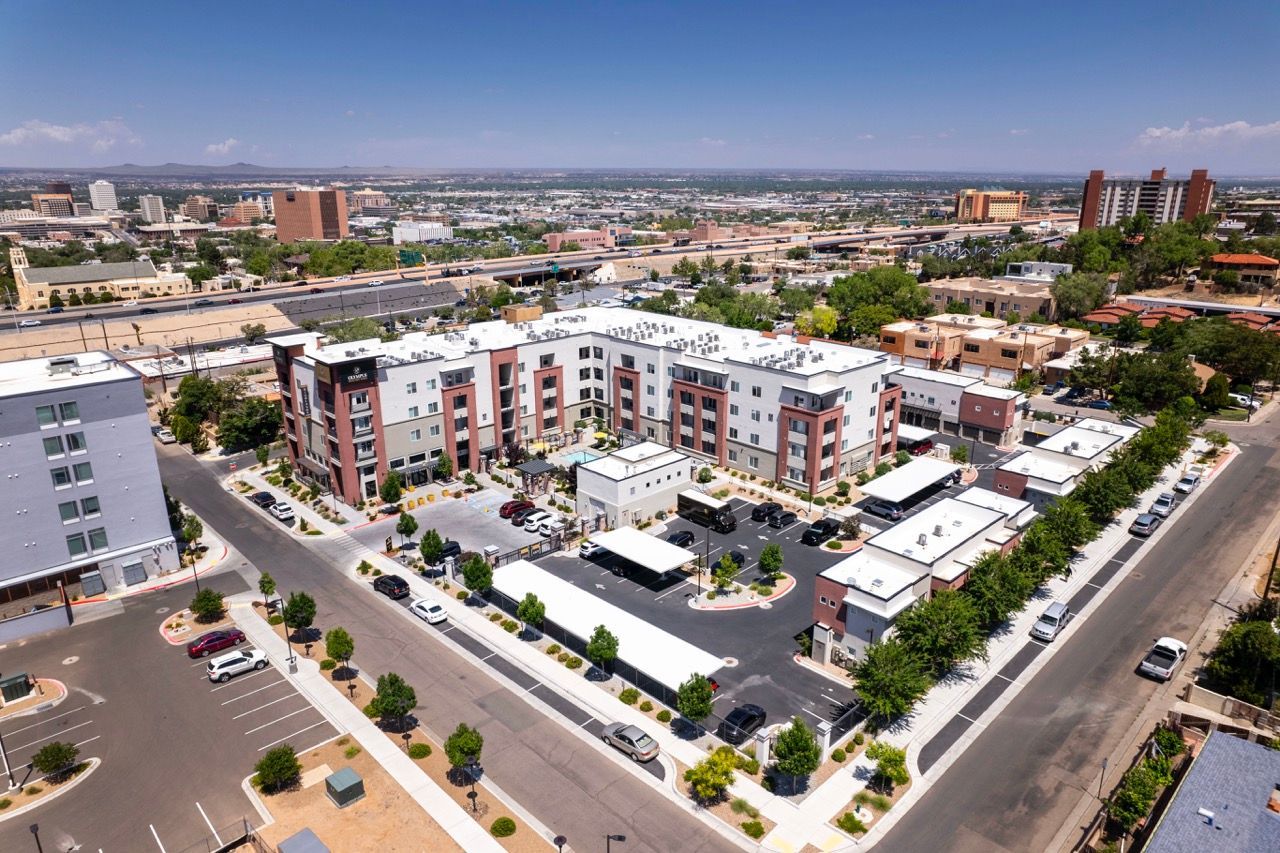 Aerial view of a modern apartment community with multiple buildings, parking, and surrounding streets.