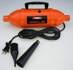 A portable hair dryer with a handle and a black nozzle is sitting on a table.