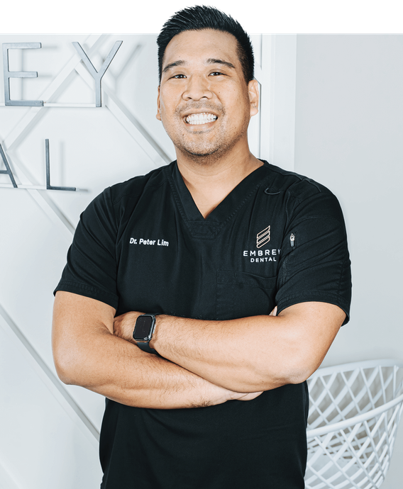 dr peter lim dentist smiling while sitting on couch in dental office