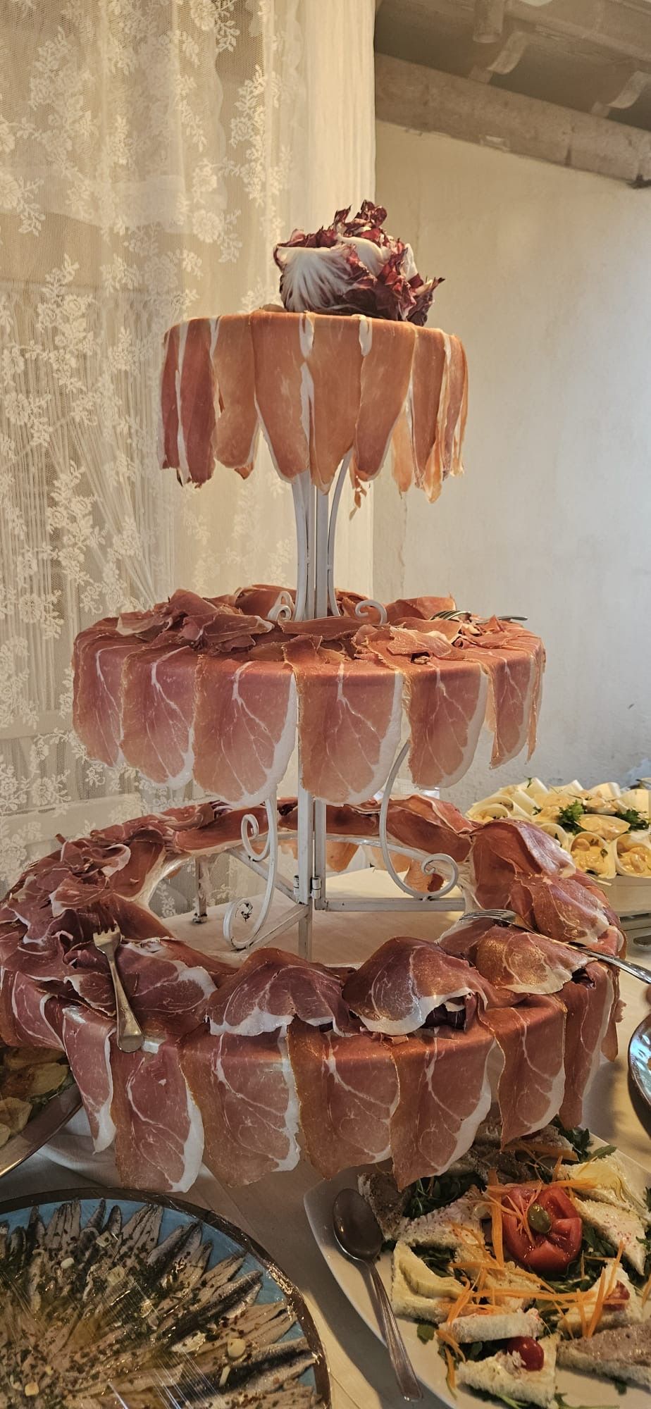 Una vetrina di salumi a più livelli con prosciutto affettato.
