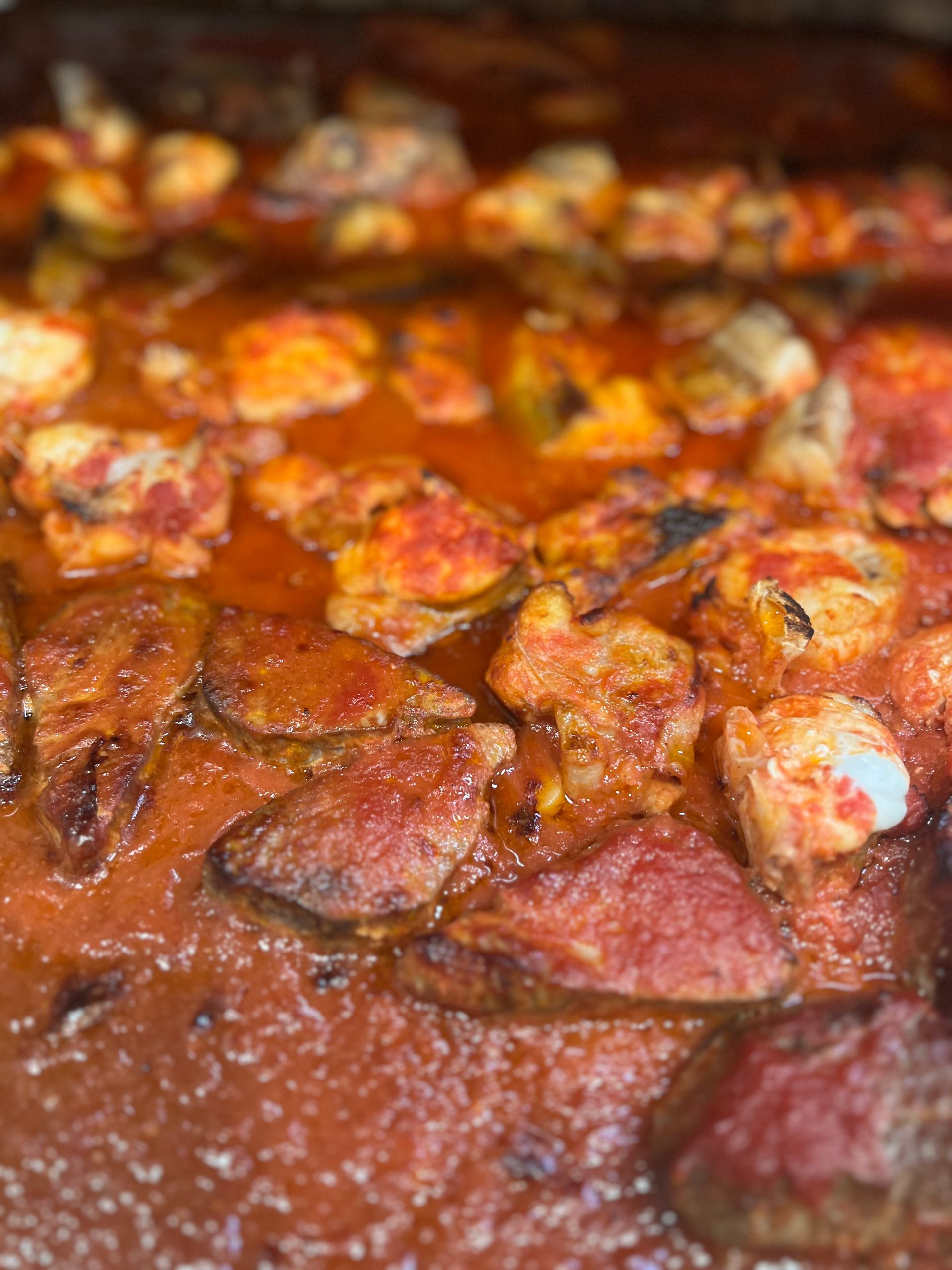 Salsiccia e pezzi di formaggio in una ricca salsa di pomodoro rosso.