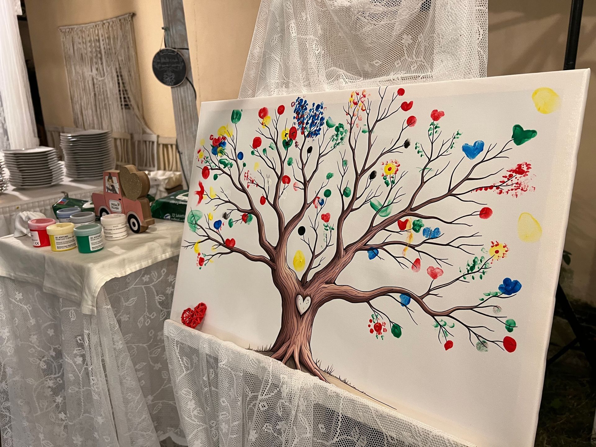 In mostra un'opera d'arte raffigurante un albero con impronte digitali, con stampe colorate al posto delle foglie.