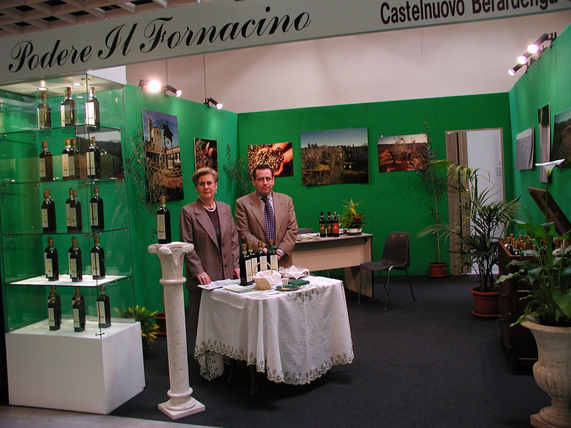 persone in posa dietro una parete di vini