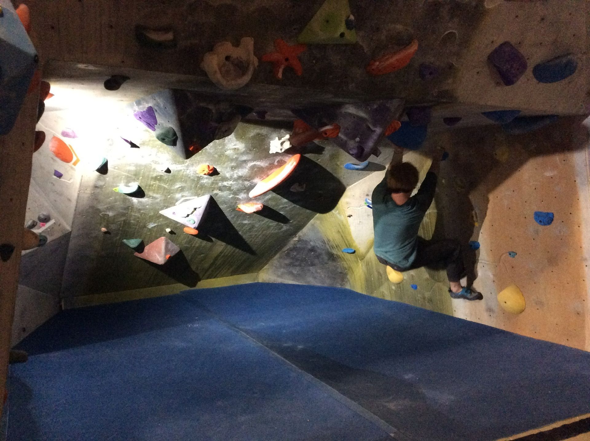 A person is climbing a rock wall in a gym.