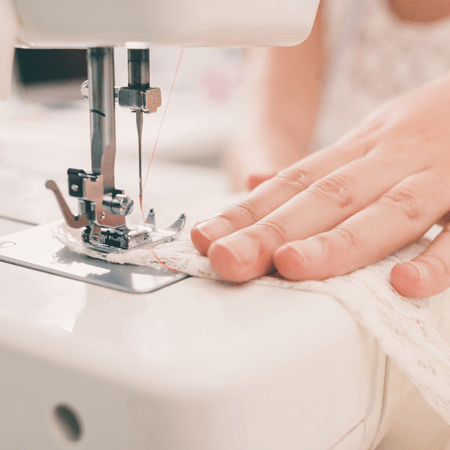 Close-up of hands sewing on machine