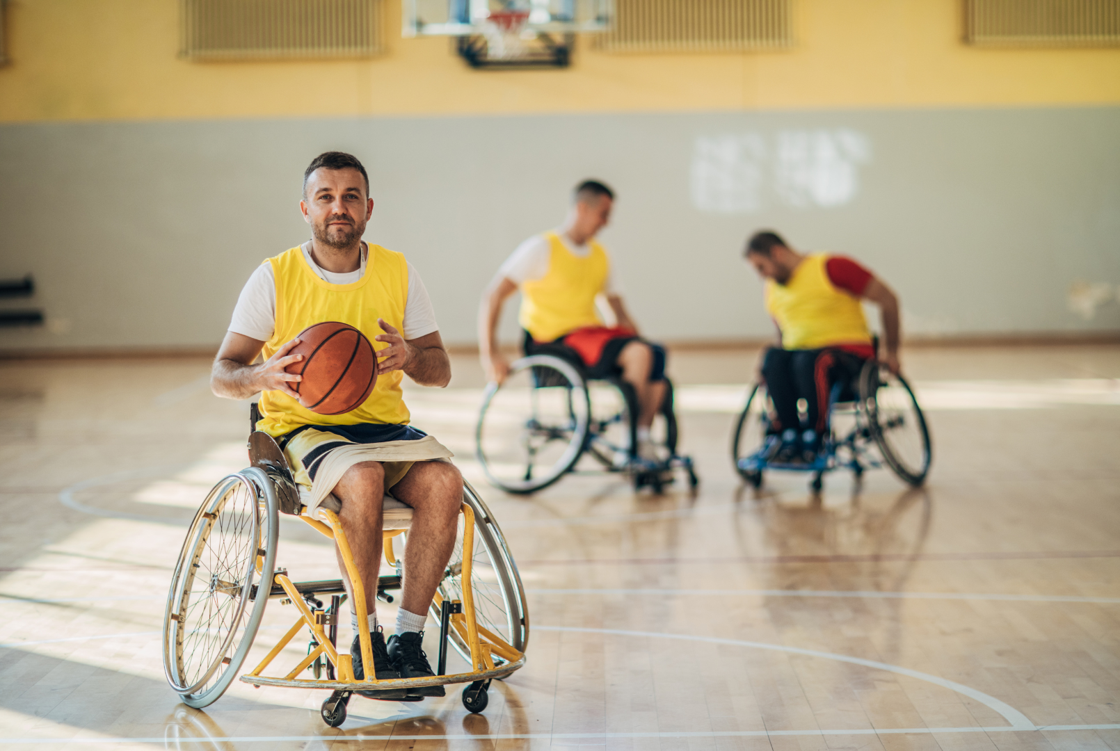 a group of men in wheelchairs are playing basketball on a court .