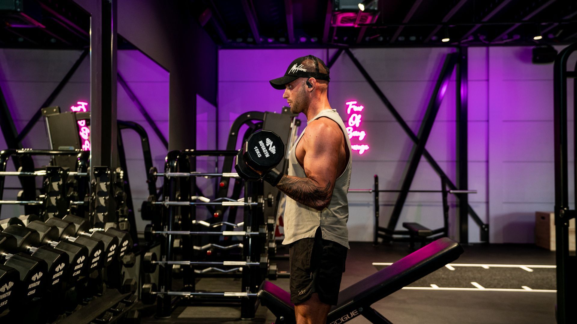 Een man tilt een halter op in een sportschool.
