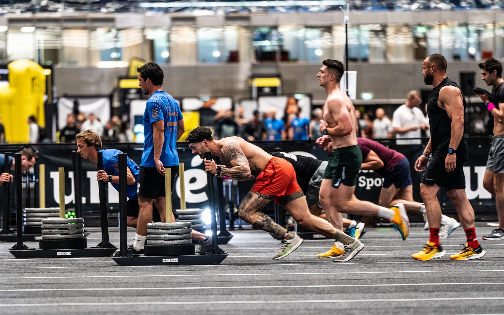 Een groep mannen rent op een atletiekbaan in een sportschool.