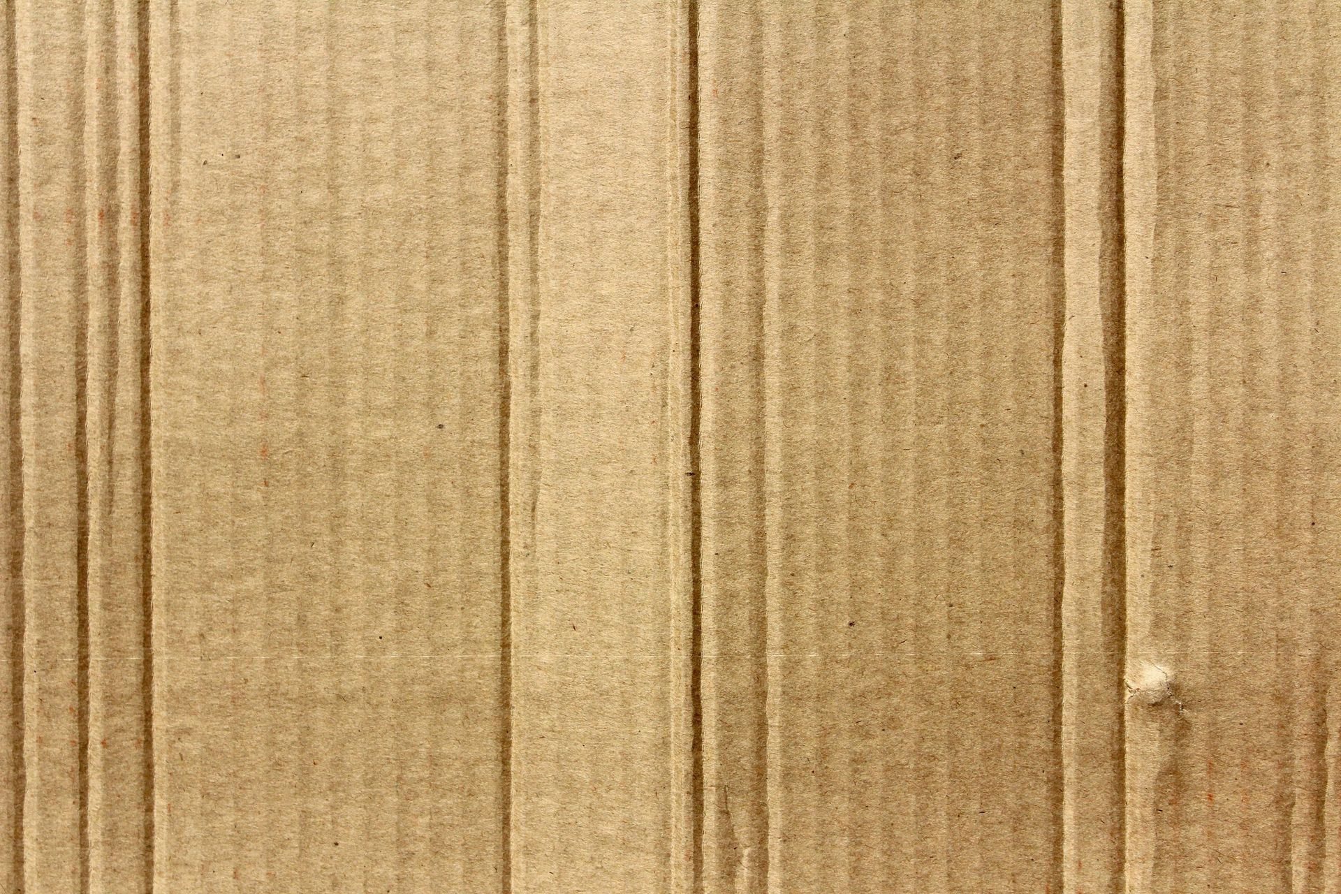 Brown corrugated cardboard texture. Vertical lines, subtle patterns.