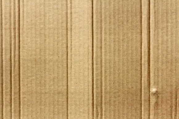 Brown corrugated cardboard texture. Vertical lines, subtle patterns.